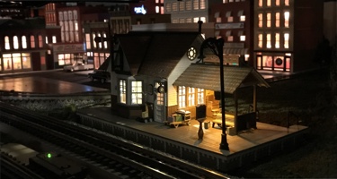 Railroad Avenue Station Layout photo of a small Woodland Scenics Frieght Depot lighted at night.