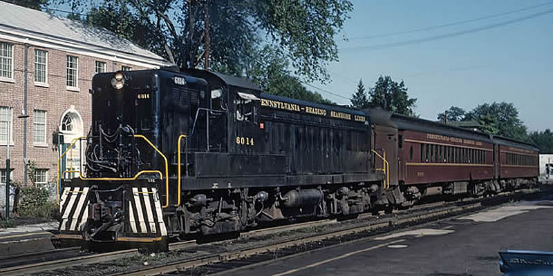 Photo of a real (full-size) PRSL locomotive pulling two passenger cars.